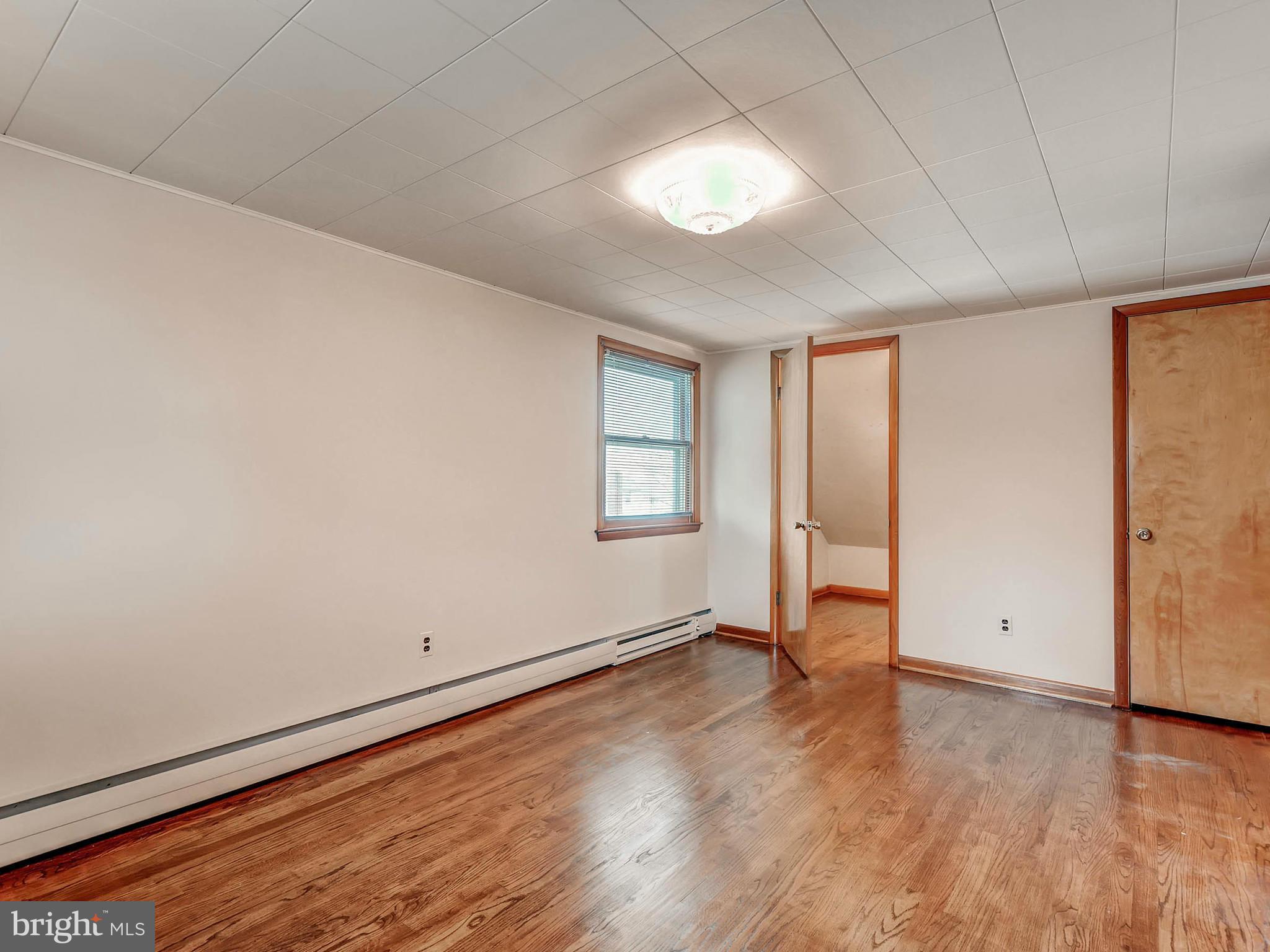 7306 Manchester Road Baltimore, MD 21222 - Photo 18 of 24 an empty room with wooden floor and windows