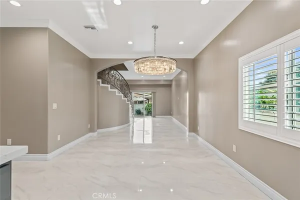 a view of a hallway with window and chandelier