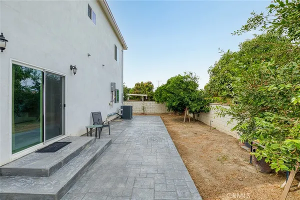 a view of a patio with couches and table and chairs next to yard