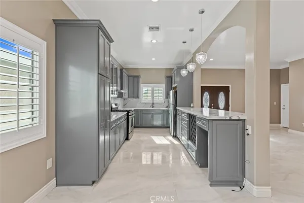 a large kitchen with a large counter top stainless steel appliances and cabinets