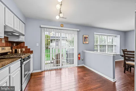 a kitchen with wooden floor and stainless steel appliances