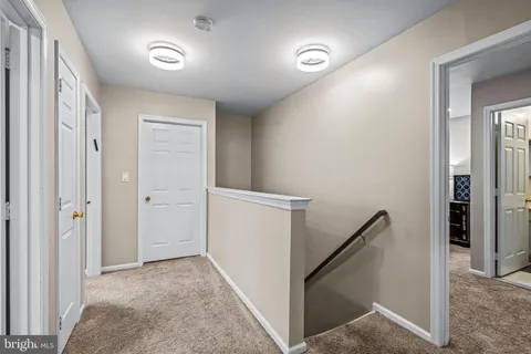 a view of hallway with stairs and wooden floor