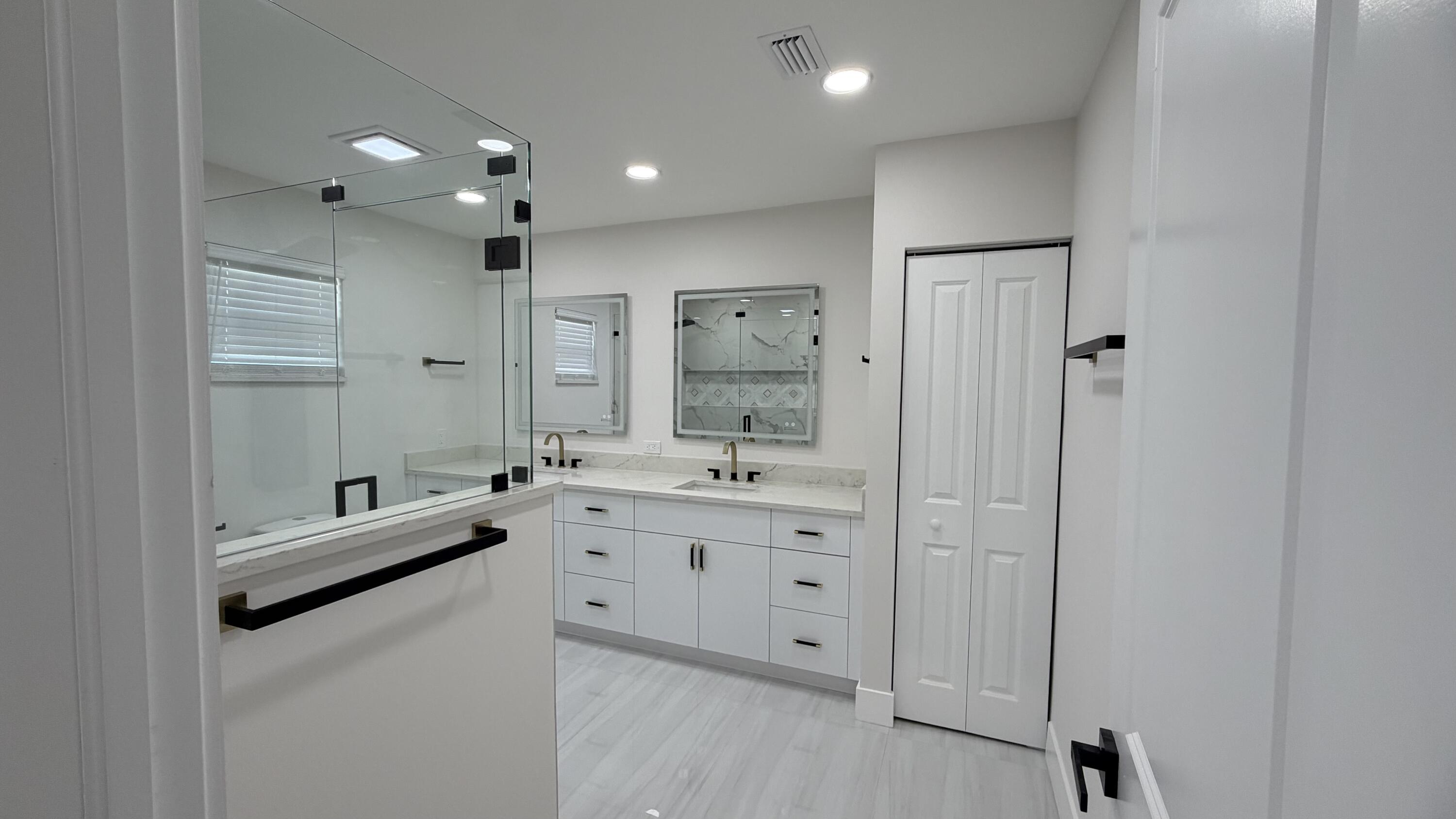 2521 Northeast 45th Street Lighthouse Point, FL 33064 - Photo 13 of 25 a bathroom with a double vanity sink a toilet a mirror and shower