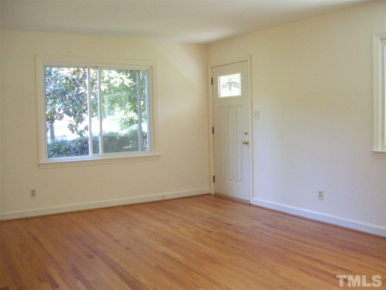 410 Jones Franklin Road Raleigh, NC 27606 - Photo 2 of 17 a view of an empty room with wooden floor and a window