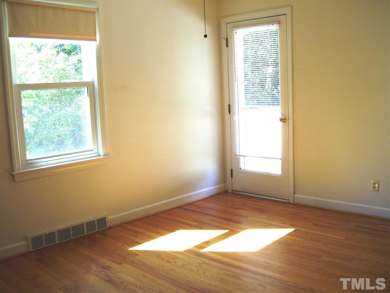 410 Jones Franklin Road Raleigh, NC 27606 - Photo 8 of 17 an empty room with wooden floor and windows