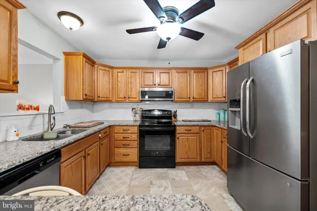 a kitchen with stainless steel appliances granite countertop a refrigerator stove top oven a sink and dishwasher