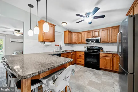 a kitchen with stainless steel appliances granite countertop a sink a stove and refrigerator