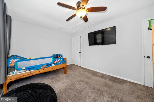 a living room with a baby crib furniture and a flat screen tv