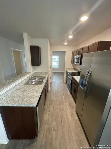 a kitchen with kitchen island granite countertop a sink stove and refrigerator