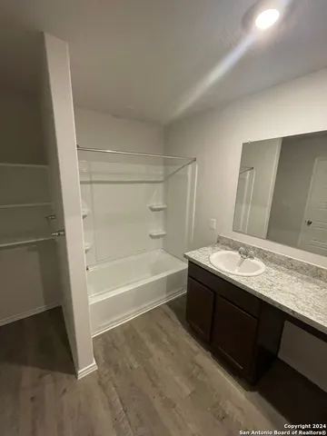 a bathroom with a granite countertop sink and a bathtub