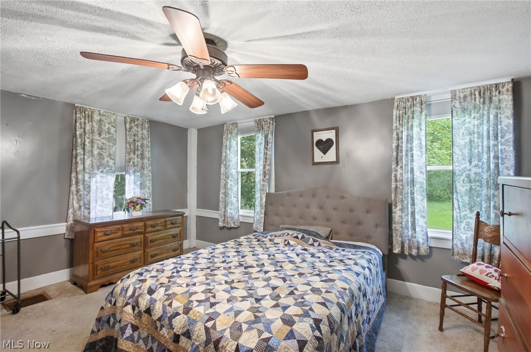 2591 Wayland Road Deerfield, OH 44411 - Photo 19 of 46 Bedroom featuring a ceiling fan with integrated lighting, multiple windows, a paneled headboard, and gray wall paint with white trim