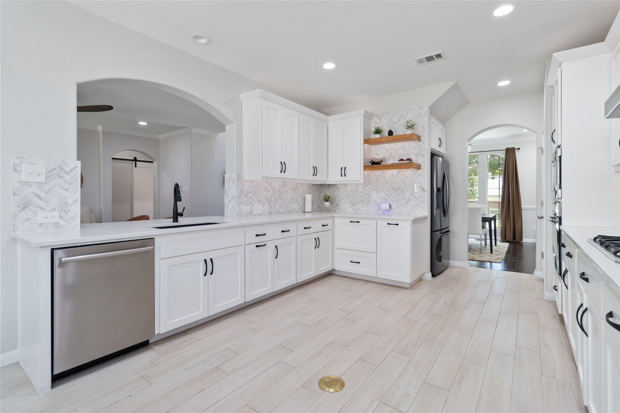 8032 Via Verde Drive Austin, TX 78739 - Photo 13 of 37 a large white kitchen with a lot of counter space and wooden floor
