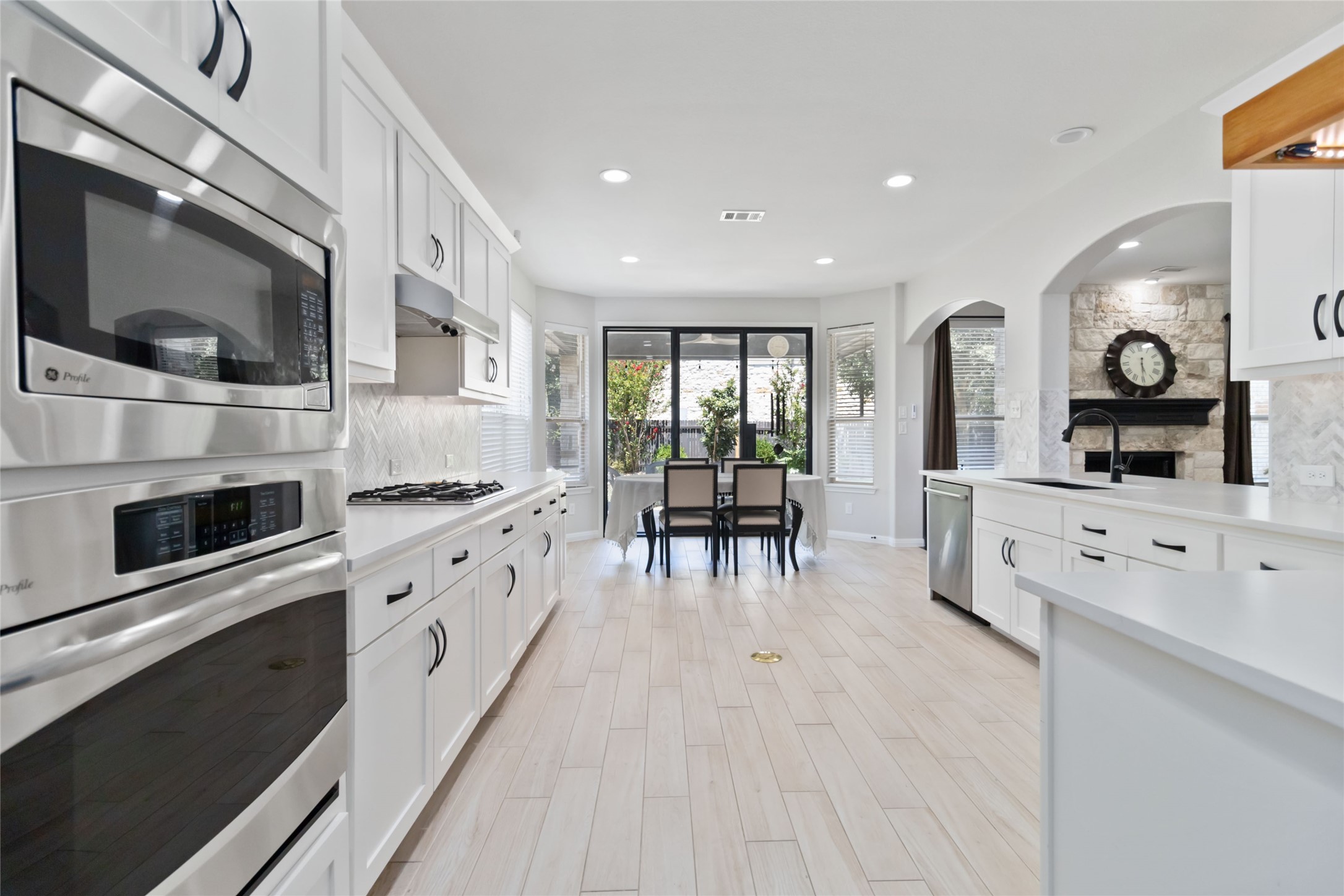 8032 Via Verde Drive Austin, TX 78739 - Photo 14 of 37 a large kitchen with stainless steel appliances a stove a sink and a microwave