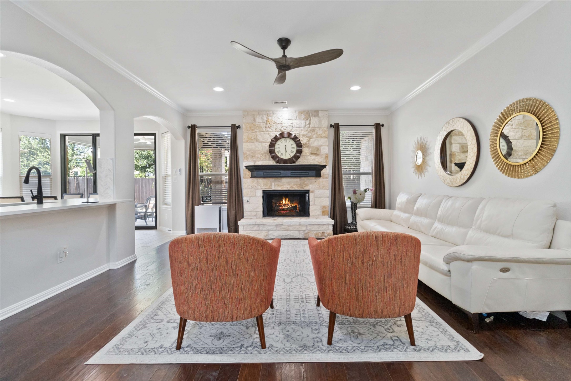 8032 Via Verde Drive Austin, TX 78739 - Photo 7 of 37 a living room with furniture a clock and a fireplace
