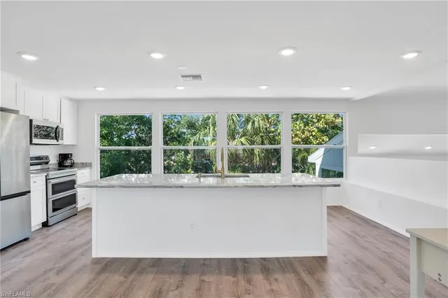 a large white kitchen with a large window