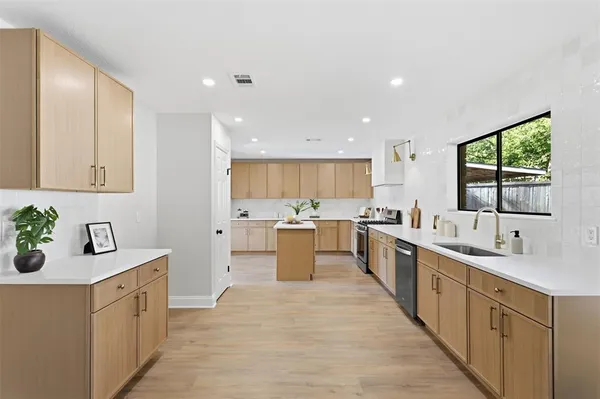 a large kitchen with stainless steel appliances lots of counter top space