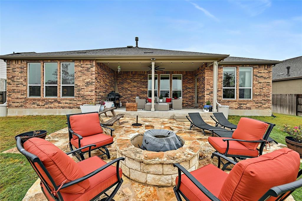 170 Climbing Rock Loop Dripping Springs, TX 78620 - Photo 20 of 30 A spacious backyard with an inviting stone fire pit and a covered patio for outdoor entertaining.