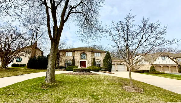 a front view of a house with a yard covered with snow