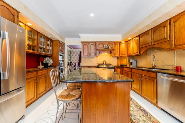 a kitchen with stainless steel appliances granite countertop sink stove and refrigerator