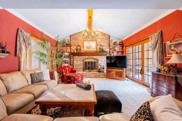 a living room with furniture a flat screen tv and a large window