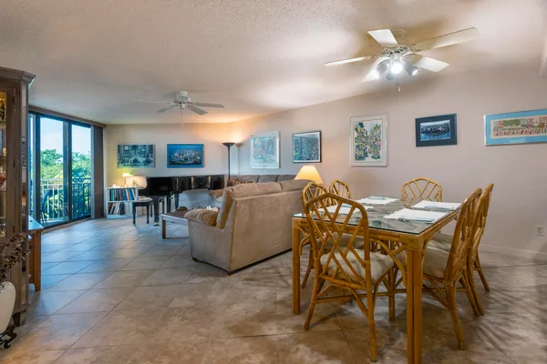 a living room with furniture a chandelier and a dining table