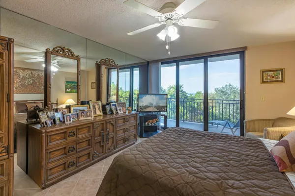 a bed room with a bed a chandelier and a large window