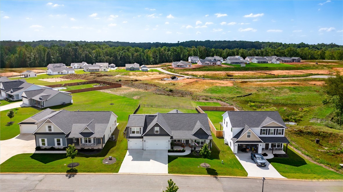 203 Legacy Lane Liberty, SC 29657 - Photo 38 of 47 This scenic aerial view captures a vibrant neighborhood with homes nestled amidst green expanses and distant trees.