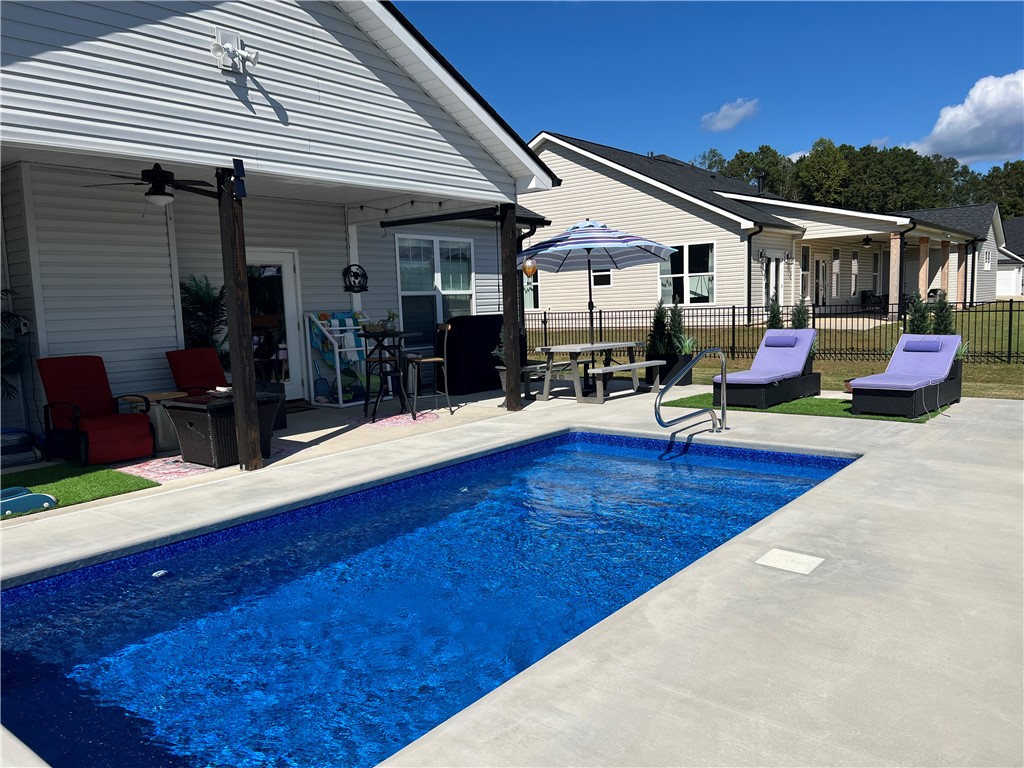 203 Legacy Lane Liberty, SC 29657 - Photo 44 of 47 An inviting backyard oasis features a clear blue pool and a covered patio, perfect for entertaining.