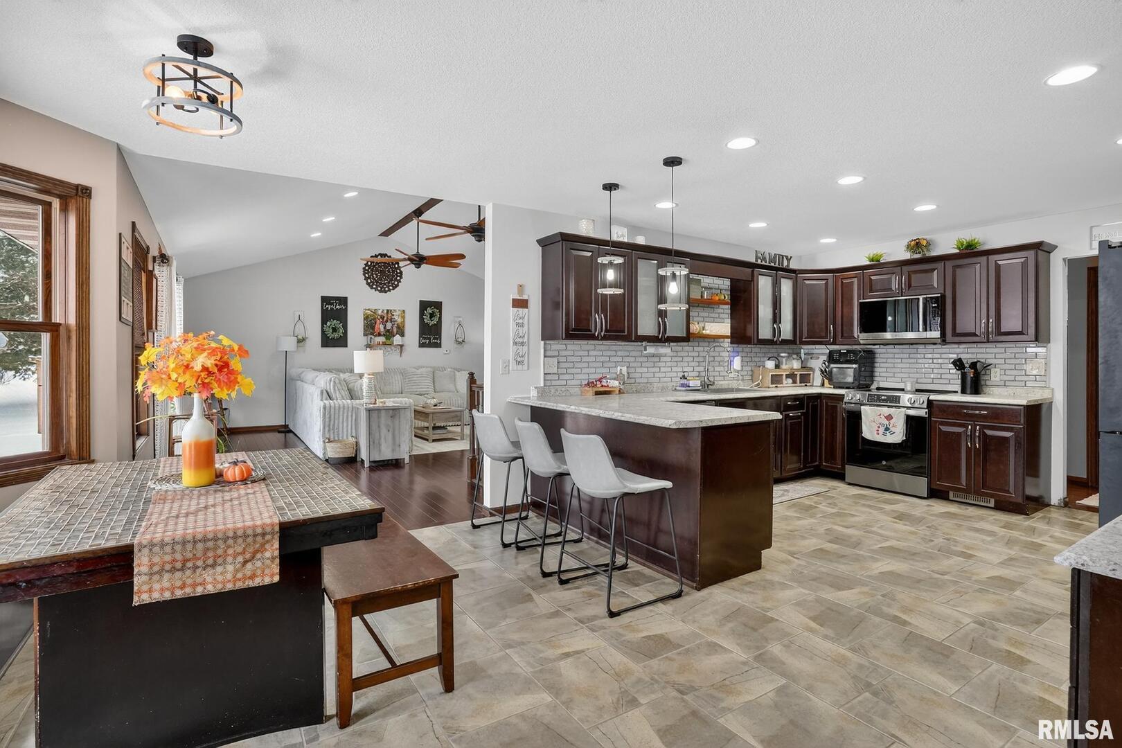 5759 Riverview Road Thomson, IL 61285 - Photo 16 of 49 a open kitchen with stainless steel appliances kitchen island granite countertop a table chairs and a sink