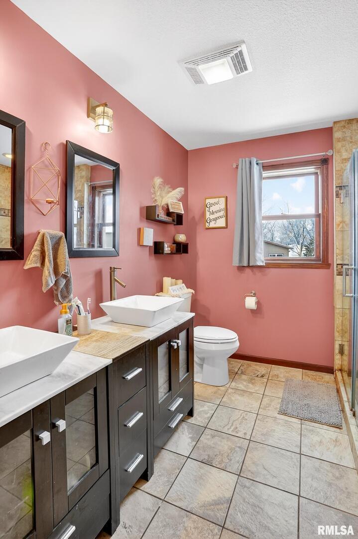 5759 Riverview Road Thomson, IL 61285 - Photo 28 of 49 a spacious bathroom with a granite countertop sink a toilet a mirror and vanity