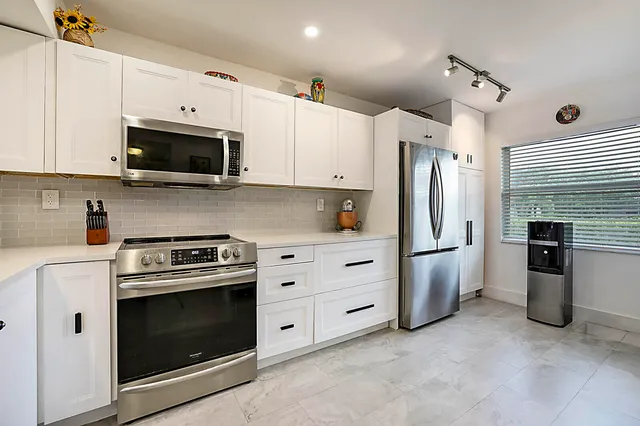 a kitchen with stainless steel appliances a stove microwave and refrigerator