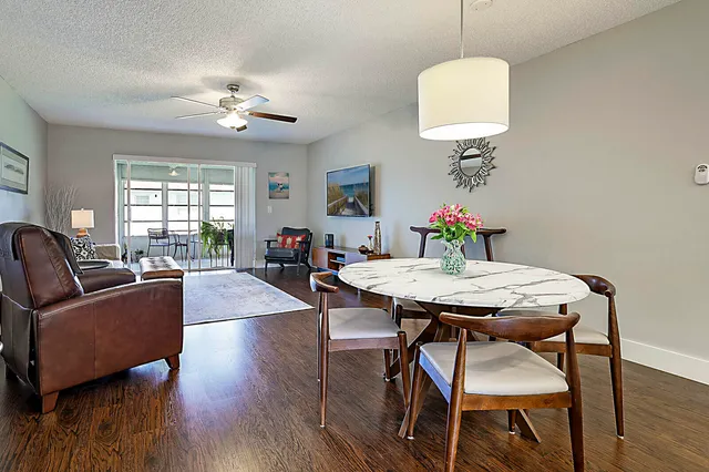 a view of a dining room with furniture a chandelier and wooden floor