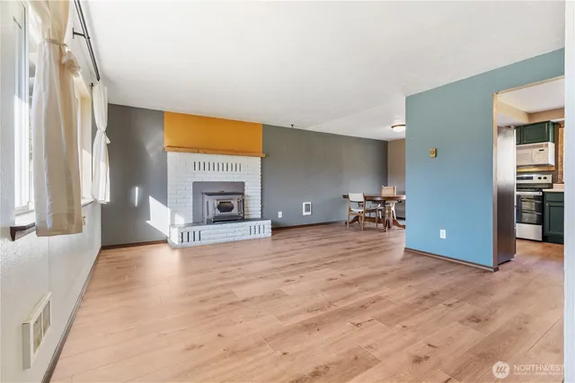 a view of an empty room with a fireplace and a window