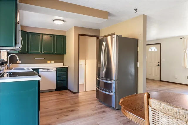 a kitchen with a refrigerator sink and wooden floor