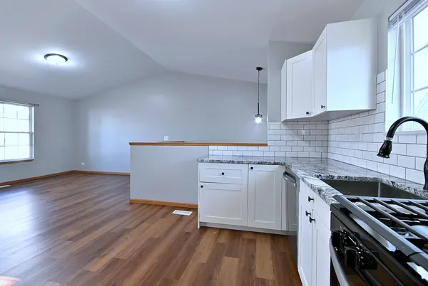 a kitchen with wooden floors and white appliances