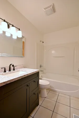 a bathroom with a granite countertop sink mirror vanity and toilet
