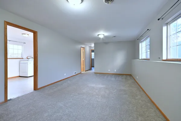 an empty room with windows and bathroom