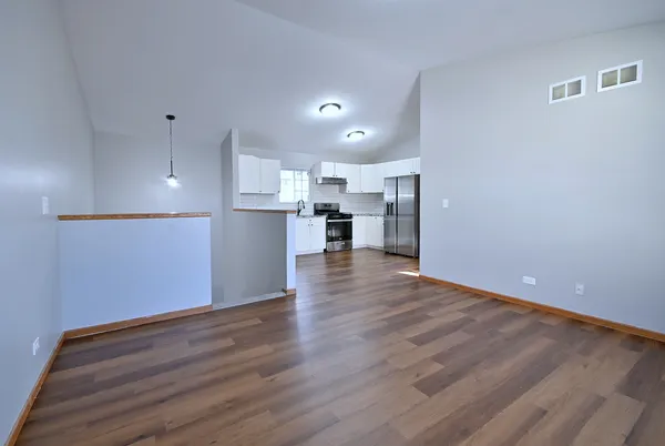a view of kitchen with wooden floor and electronic appliances