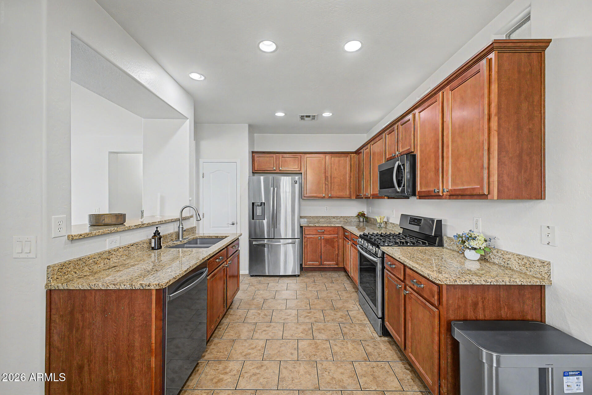2868 South Anderson Lane Gilbert, AZ 85295 - Photo 13 of 59 a kitchen with stainless steel appliances granite countertop a stove a sink dishwasher and a refrigerator with wooden cabinets