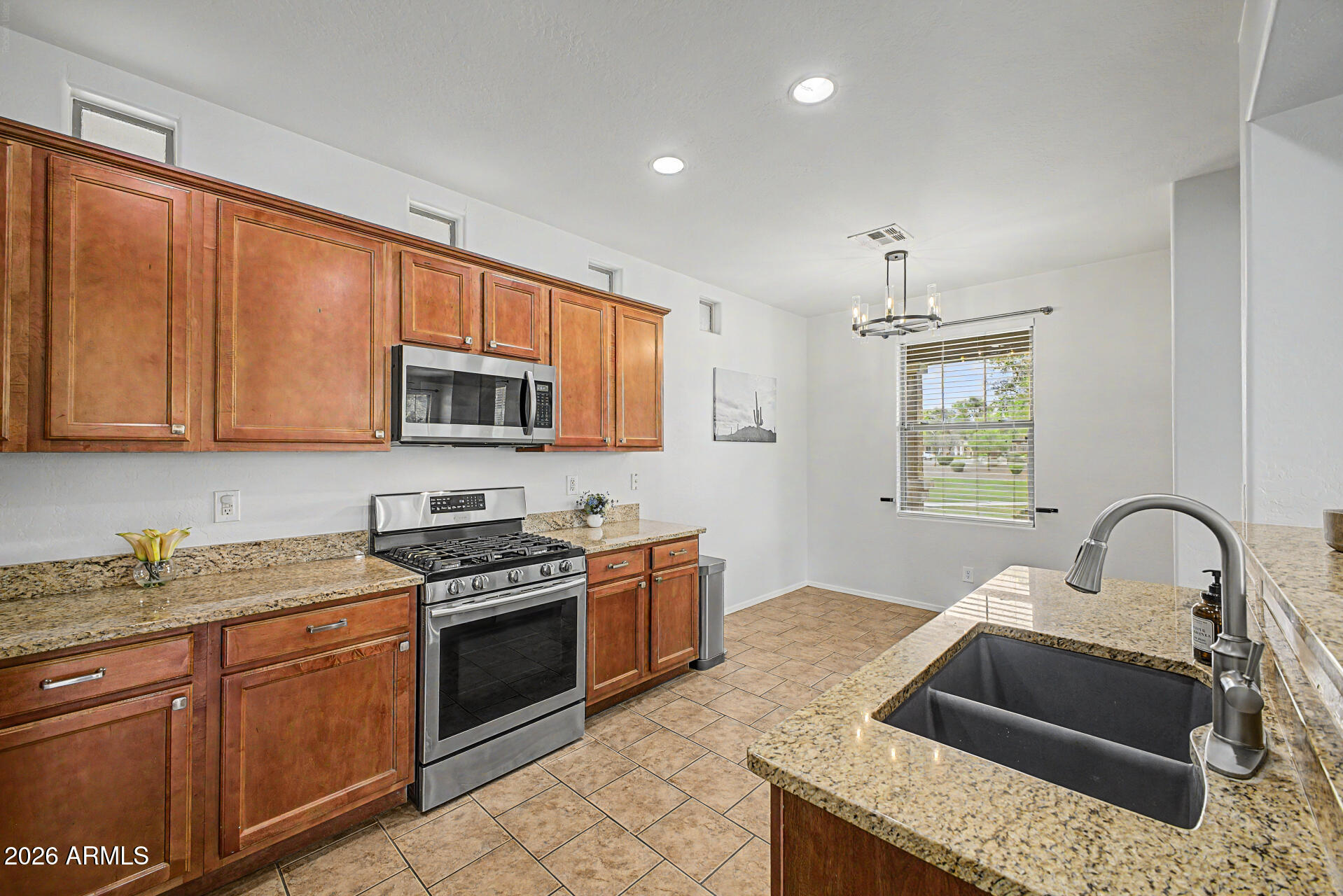 2868 South Anderson Lane Gilbert, AZ 85295 - Photo 15 of 59 a kitchen with granite countertop stainless steel appliances sink stove and microwave