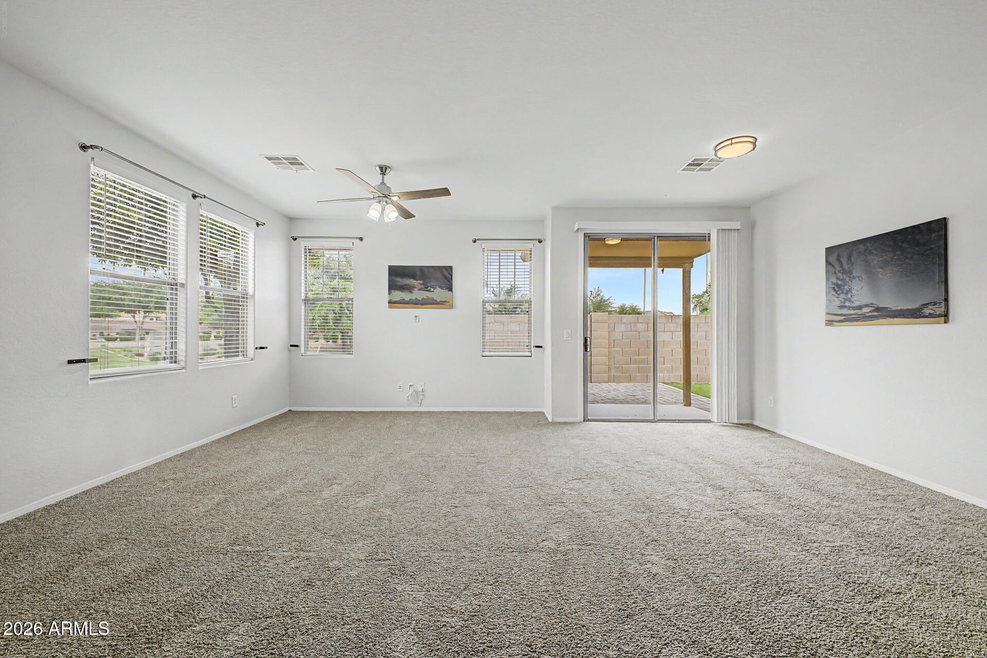 2868 South Anderson Lane Gilbert, AZ 85295 - Photo 8 of 59 an empty room with windows and chandelier fan