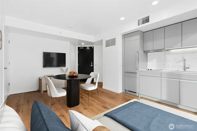 a living room with furniture a flat screen tv and kitchen view