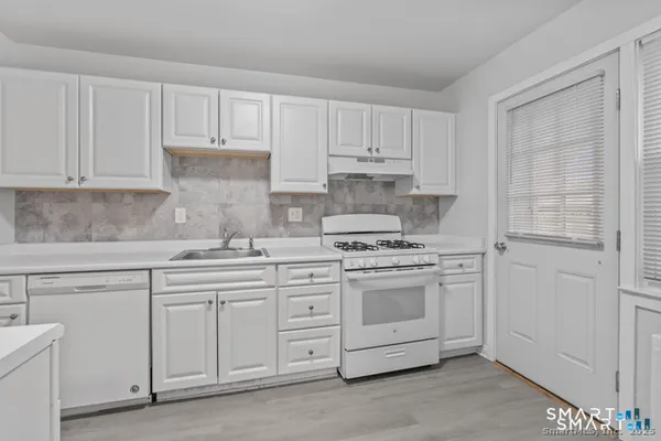 a kitchen with white cabinets and white appliances