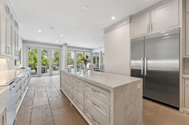 a large white kitchen with a large window