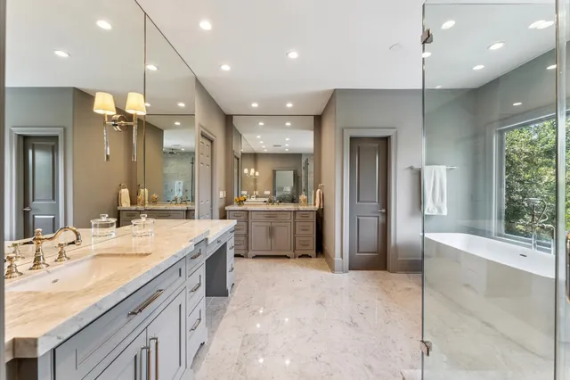 a large bathroom with a large mirror vanity and shower