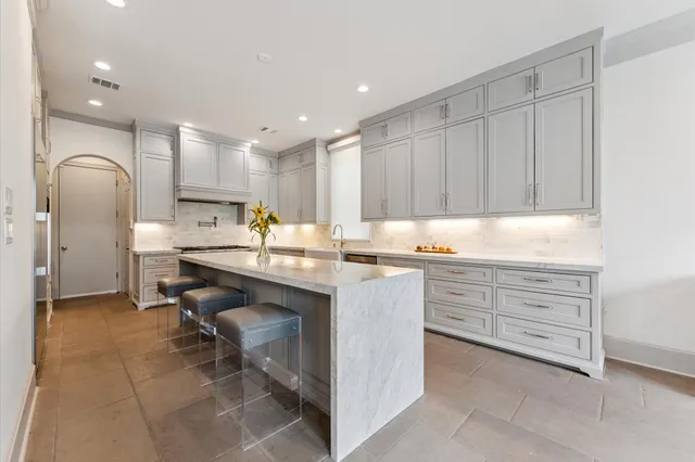 a kitchen with granite countertop a sink stainless steel appliances and cabinets