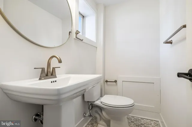 a bathroom with a sink a toilet and mirror