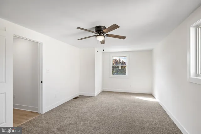 a view of a room with a ceiling fan and a window