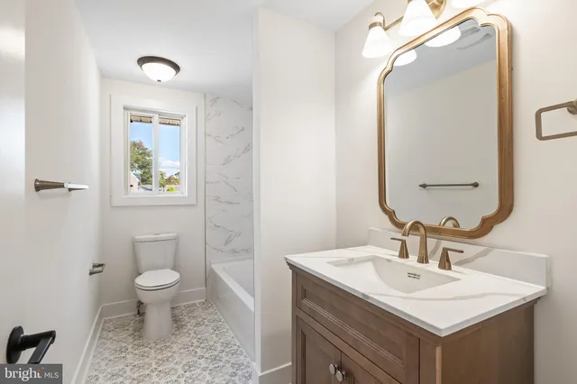 a bathroom with a sink toilet and a mirror