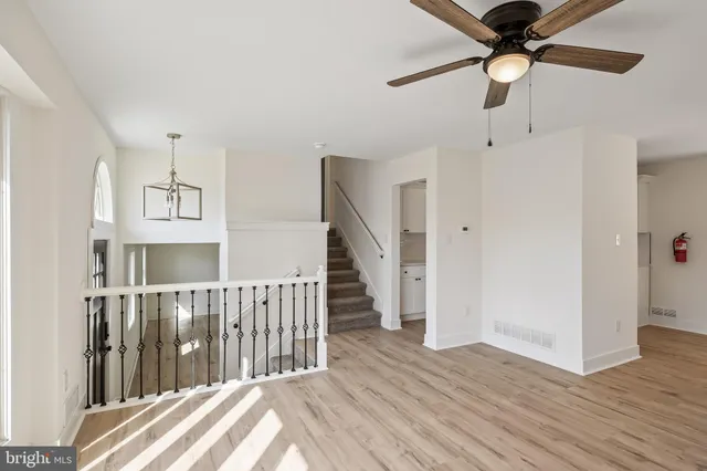 a view of a hallway with wooden floor and entryway